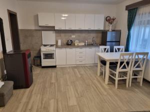 a kitchen with white cabinets and a table and chairs at Kuća za odmor Vasiljević in Ljig