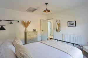 ein Schlafzimmer mit einem weißen Bett und einer Kommode in der Unterkunft Pentwyn Cottage, Bwlch Brecon in Bwlch