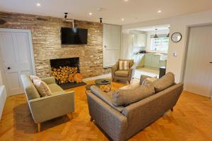 ein Wohnzimmer mit zwei Sofas und einem Kamin in der Unterkunft Pentwyn Cottage, Bwlch Brecon in Bwlch