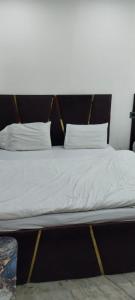 Una cama con sábanas blancas y almohadas. en Hotel Luxery Inn - Paharganj, en Nueva Delhi