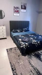 ein Schlafzimmer mit einem Bett mit einer blauen Decke und einem Teppich in der Unterkunft POOL CaSSa Ardina pantai Batu hitam 4rooms in Kuantan + 7 Fotos