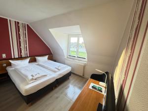a small bedroom with a bed and a window at Hotel Brinckmansdorf in Rostock