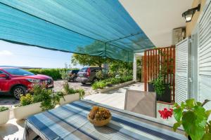 une terrasse avec une table et un auvent bleu dans l'établissement Apartments Boro, à Dugi Rat