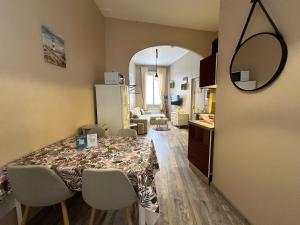 a room with a table and chairs and a kitchen at A l'abri des vagues in Cayeux-sur-Mer