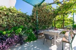 un patio avec une table et des plantes dans l'établissement Apartments Boro, à Dugi Rat
