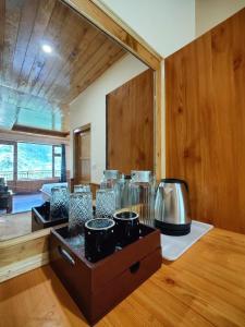 a room with a counter with many pots and a mirror at Yellow Stone Cottage and Cafe in Jibhi
