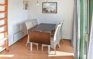 a dining room table and chairs in a room at Cozy Home In Hanstholm With Private Swimming Pool, Can Be Inside Or Outside in Pugdal