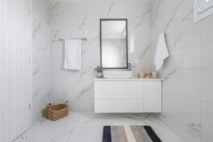 a white bathroom with a sink and a mirror at Athena Home South Crete in Kapparianá +26 photos