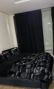a bedroom with a black bed with a black comforter at Lily Manzil in Ain Cheggag