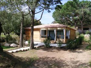 a small wooden house in a yard with trees at Résidence & Hotel U Livanti ECOLABEL in Propriano