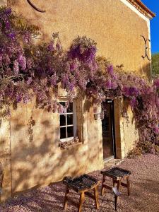 un edificio con fiori viola sul lato di La Palombière a Saint-Clar