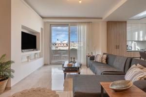 a living room with a couch and a tv at Athena Home South Crete in Kapparianá