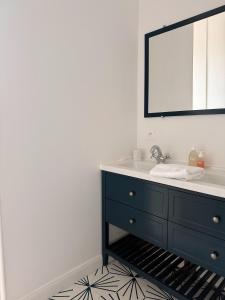 ein Badezimmer mit einem blauen Waschbecken und einem Spiegel in der Unterkunft La villa Genette, Maison proche centre-ville in La Rochelle