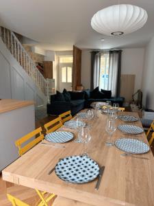 ein Tisch mit Gläsern und Tellern darauf in einem Wohnzimmer in der Unterkunft La villa Genette, Maison proche centre-ville in La Rochelle