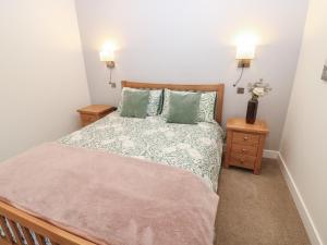 ein Schlafzimmer mit einem großen Bett und zwei Nachttischen in der Unterkunft Cobble Cottage in Long Marton