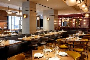 un ristorante con tavoli e sedie in legno e un bar di Hotel 55 a Chicago