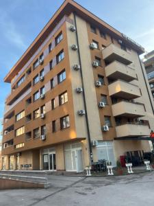 a large apartment building with balconies in a parking lot at Bulevar in Sarajevo