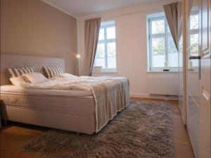 una camera da letto con un letto, un tappeto e finestre di Kleine Freiheit EG bis 6 Pers a Kopendorf