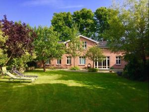 una grande casa in mattoni con un parco giochi nel cortile di Kleine Freiheit EG bis 6 Pers a Kopendorf