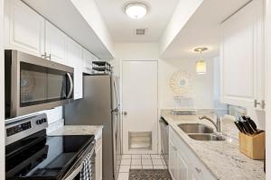 a kitchen with white cabinets and a stainless steel refrigerator at PW13105: 13105 Pelican Watch in Seabrook Island
