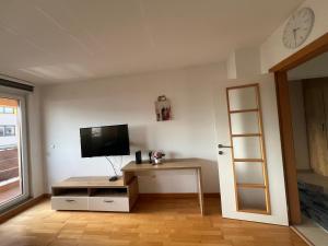 a living room with a tv and a desk with a table at Bulevar in Sarajevo