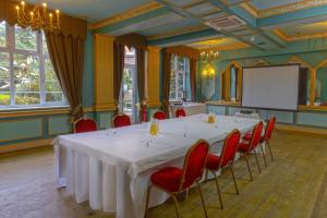 een vergaderzaal met een witte tafel en rode stoelen bij Best Western Abbots Barton Hotel in Canterbury