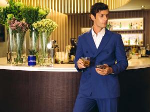 a man in a blue suit holding a glass at Novotel Athens in Athens +221 photos