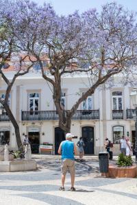 ラゴスにあるCasa Margôの建物の前に立っている男性 +17枚の写真