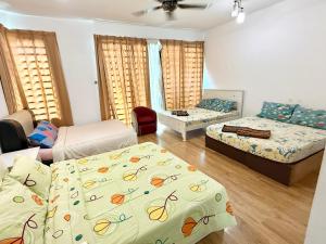ein Wohnzimmer mit zwei Betten und einer Couch in der Unterkunft 7BR Penang Stay Near Gurney and George Town in Tanjong Tokong