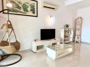 ein Wohnzimmer mit einem Flachbild-TV und einer Schaukel in der Unterkunft 7BR Penang Stay Near Gurney and George Town in Tanjong Tokong