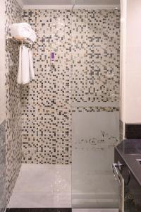 una ducha con puerta de cristal en un baño en Aracan Hotac Ras El Bar, en Ras El Bar 32 fotos más