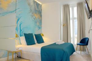 una camera da letto con un letto dipinto di blu sul muro di Lisbon Studios a Lisbona