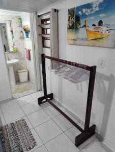 a towel rack in a bathroom with a painting on the wall at Espaço inteiro-Praia de Barequeçaba - São Sebastião -SP in São Sebastião