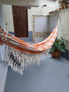 a hammock hanging in a room with a plant at Espaço inteiro-Praia de Barequeçaba - São Sebastião -SP in São Sebastião