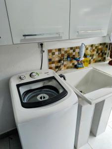 a washing machine in a kitchen next to a sink at Espaço inteiro-Praia de Barequeçaba - São Sebastião -SP in São Sebastião