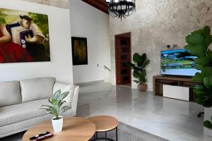 a living room with a couch and a tv at Palos altos house Poblado 6 min to Provenza in El Poblado
