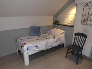 a small bedroom with a bed and a chair at Welca in Baarlo