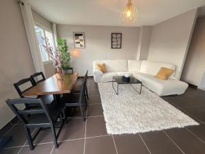 a living room with a white couch and a table at Maison moderne avec terrasse & parking in Clermont-Ferrand