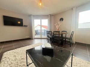 a living room with a table and a dining room at Maison moderne avec terrasse & parking in Clermont-Ferrand