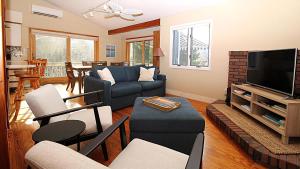 un salon avec un canapé et une télévision dans l'établissement Renascence Cottage, à Cape May Point