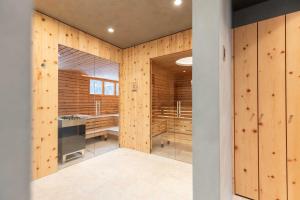 un baño con paredes revestidas de madera y una puerta de cristal en Hotel Albris, en Pontresina 56 fotos más