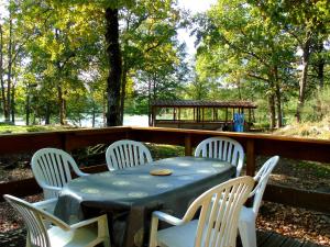 ein Tisch und Stühle auf einer Terrasse mit einem Tisch und Stühlen in der Unterkunft Les chalets au bord de l'étang de Malleteix in Champagnat