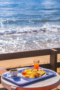 a tray of food on a table next to the ocean at Mar a Vista by Concavus in Porto De Galinhas