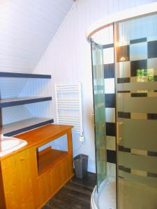 ein Bad mit einer Dusche mit einer Holztheke und einem Waschbecken in der Unterkunft Les chalets au bord de l'étang de Malleteix in Champagnat