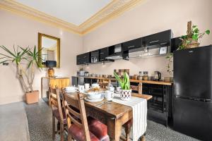 a dining room with a table with chairs and a refrigerator at Spacious Apartment with Balcony, Clarendon Square in Leamington Spa