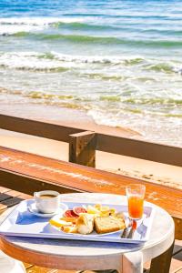 a tray of food on a table next to the beach at Mar a Vista by Concavus in Porto De Galinhas