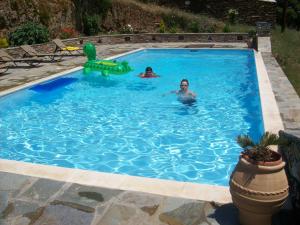 two people swimming in a swimming pool at Vassiliki Studios in Andros