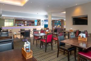 a dining room with tables and chairs in a restaurant at Holiday Inn Express London Greenwich by IHG in London +58 photos