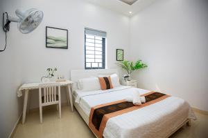 - une chambre avec 2 lits, un bureau et un ventilateur dans l'établissement Ruby Hotel Biển Vũng Tàu, à Vung Tau 22 autres photos