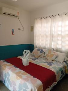 a bedroom with a bed with a heart shaped towel at Pousada La Floratta in Paulista +65 photos